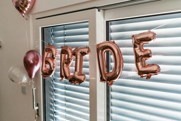 Rose gold BRIDE balloon decorations with heart-shaped and clear balloons — festive bachelorette party setup for games, entertainment, and celebration.