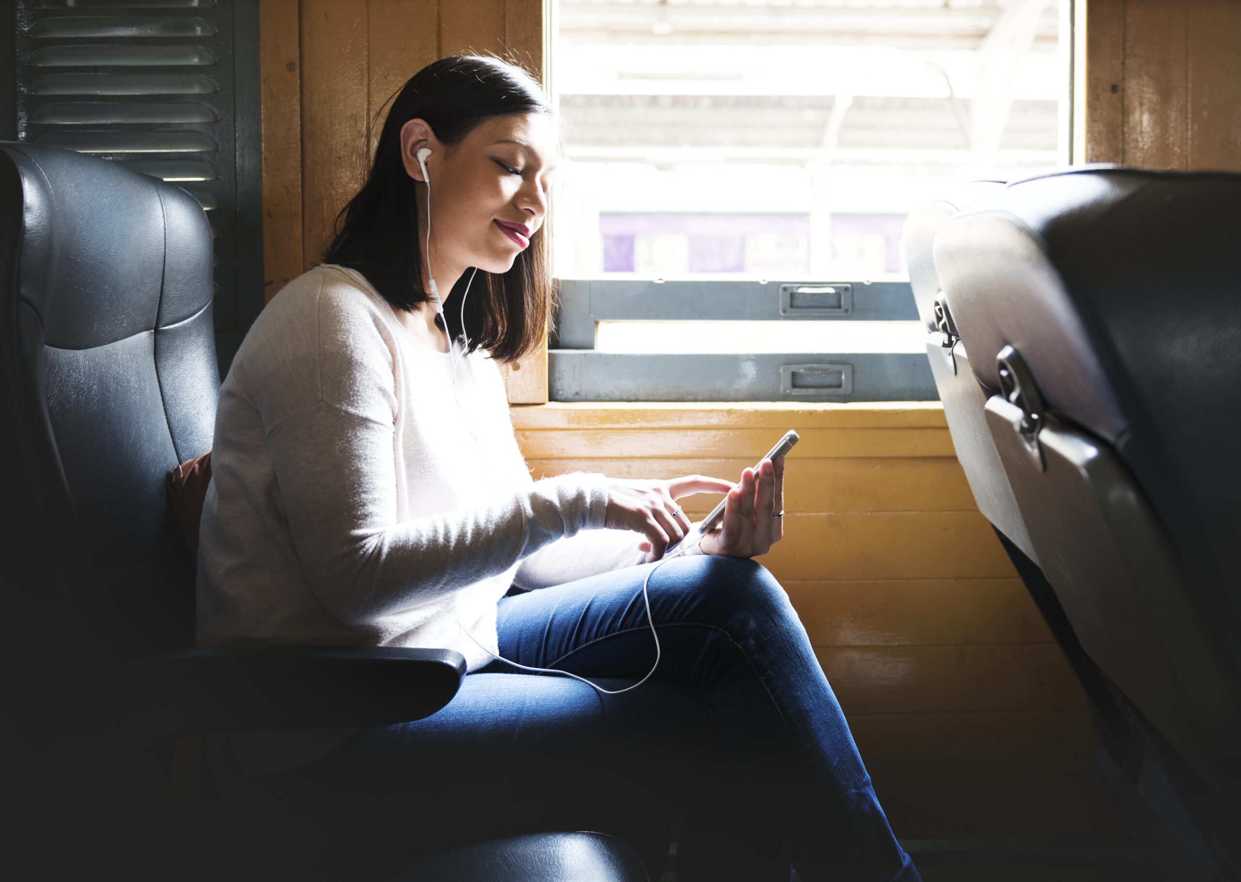 asian-woman-riding-train-scaled-listening-music