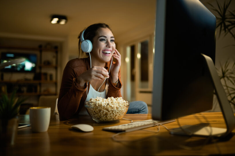 happy-woman-eating-popcorn-watching-movie-desktop-pc-while-enjoying-night-her-apartment