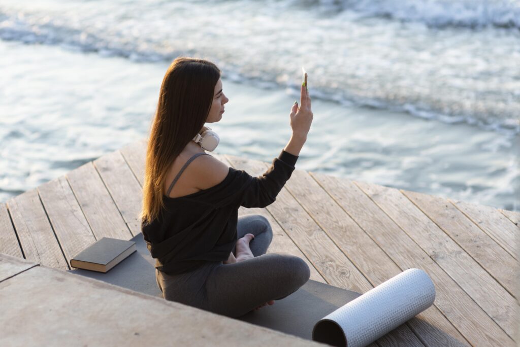 ideways-woman-taking-photo-sea