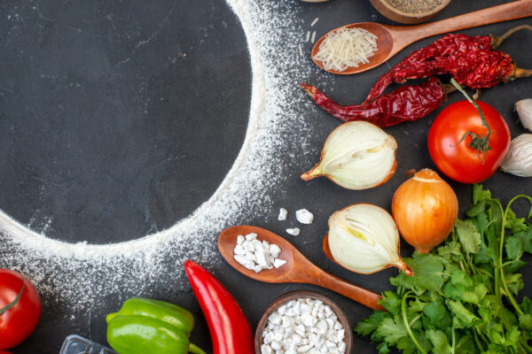top-view-sprinkled-flour-circle-tomatoes-onions-rice-wooden-spoon-coriander-table-free-space-scaled